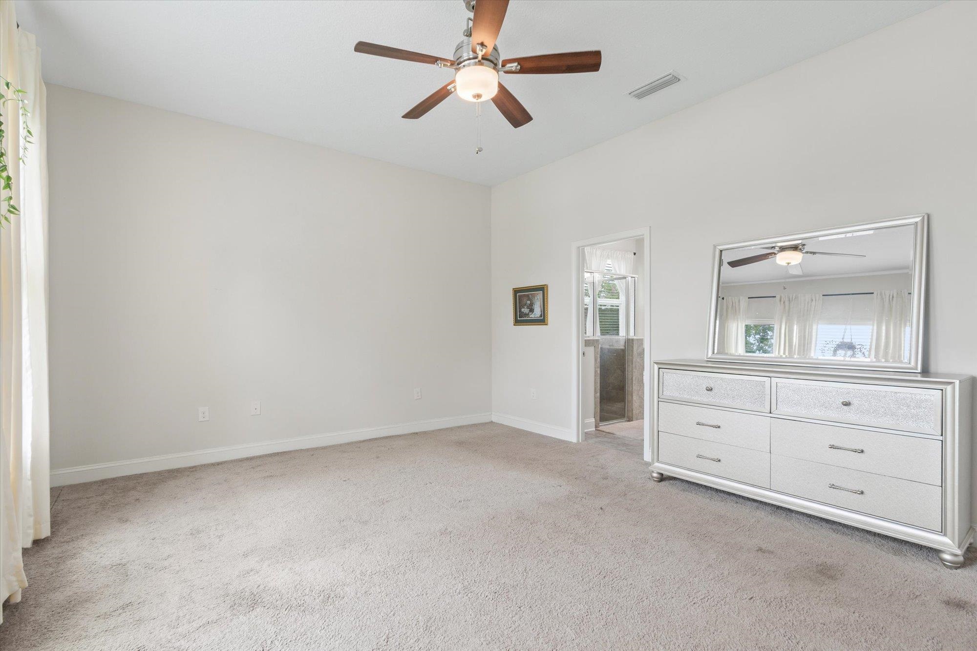 256 Vivian James Drive St. Augustine, FL 32092 - Photo 27 of 57 an empty room with chandelier fan and windows
