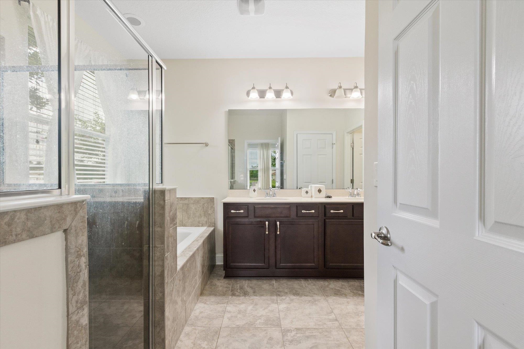 256 Vivian James Drive St. Augustine, FL 32092 - Photo 28 of 57 a spacious bathroom with a double vanity sink a mirror a bathtub and window