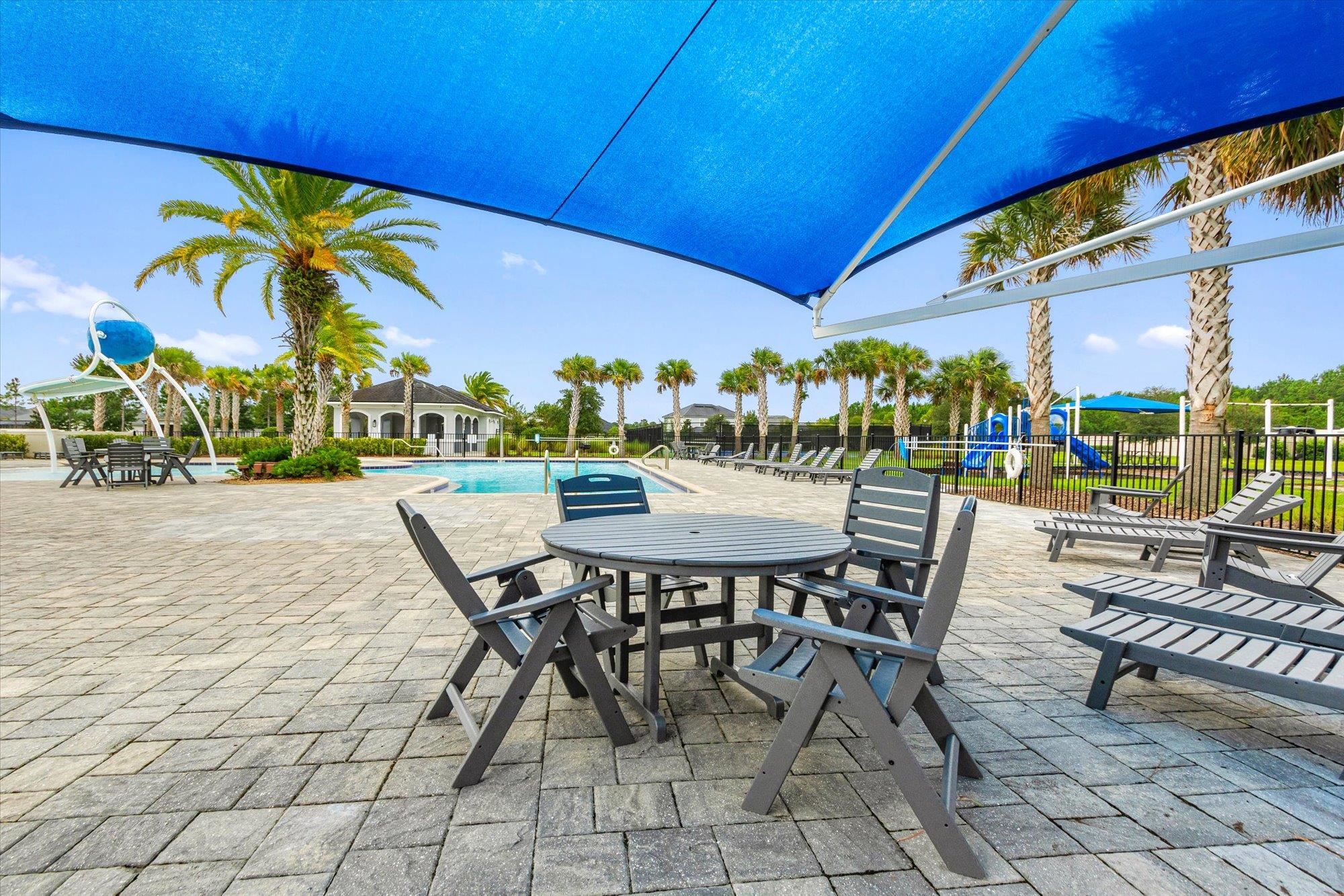 256 Vivian James Drive St. Augustine, FL 32092 - Photo 49 of 57 a view of a patio with a table and chairs under an umbrella