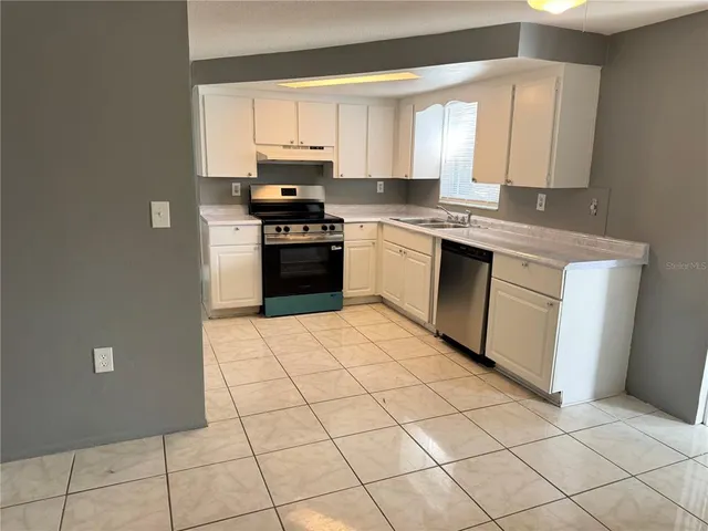 a kitchen with a sink a stove and cabinets