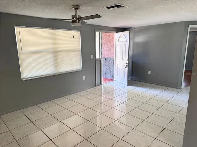 an empty room with windows and cabinet