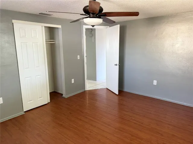 an empty room with wooden floor and bathroom