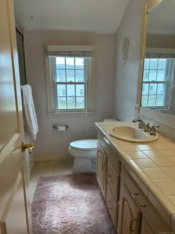 a bathroom with a sink a toilet and window