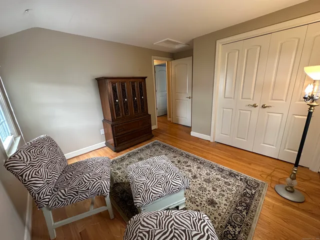a bedroom with a rug and wooden floor