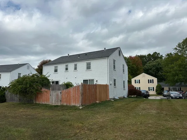 a view of a white house with backyard and garden