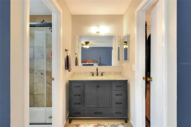 a bathroom with a granite countertop sink a large mirror and a toilet