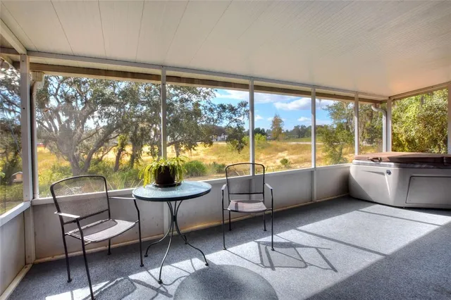 a living room with furniture a rug a large window and a table