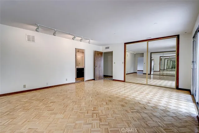 an empty room with windows and closet