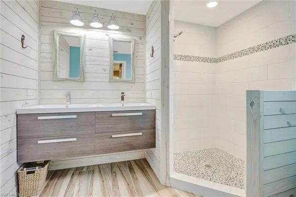 a bathroom with a sink mirror and a shower