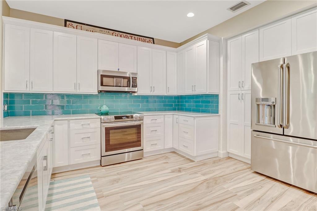 10037 Heather Lane, Unit 4 Naples, FL 34119 - Photo 11 of 24 a kitchen with granite countertop a refrigerator and a sink