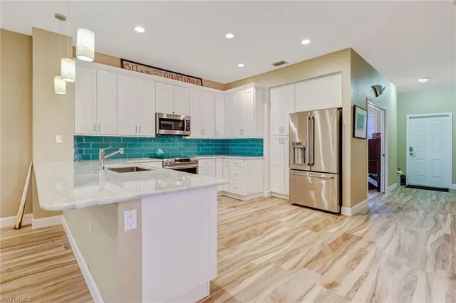 a kitchen with granite countertop a refrigerator and a stove top oven