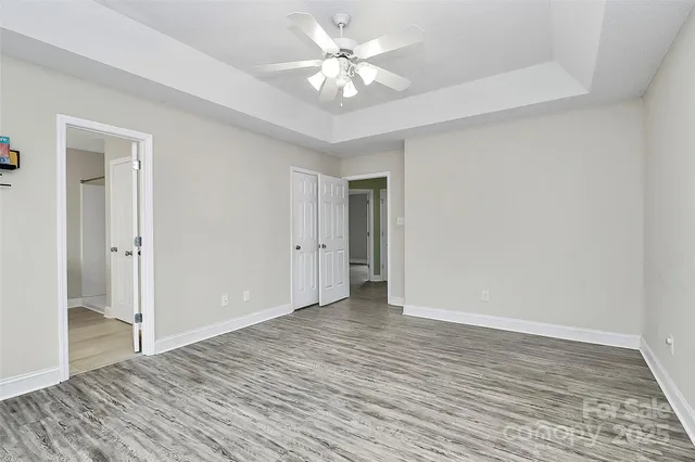 a view of an empty room with window and a chandelier fan