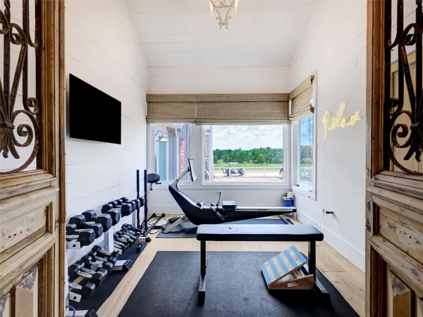 a living room with furniture a flat screen tv and a large window