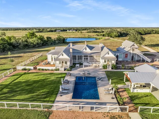 an aerial view of residential houses with outdoor space and ocean view