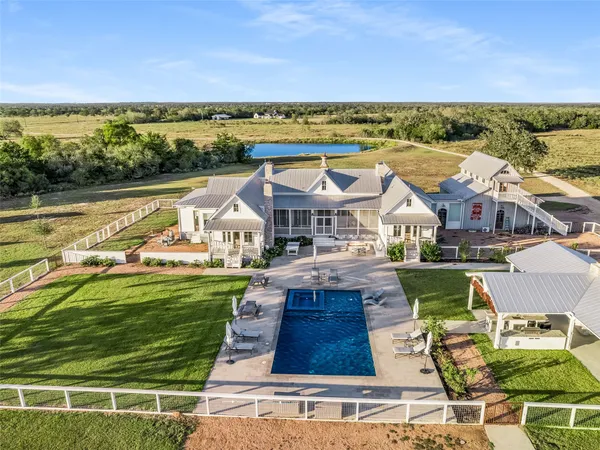 an aerial view of residential houses with outdoor space and ocean view