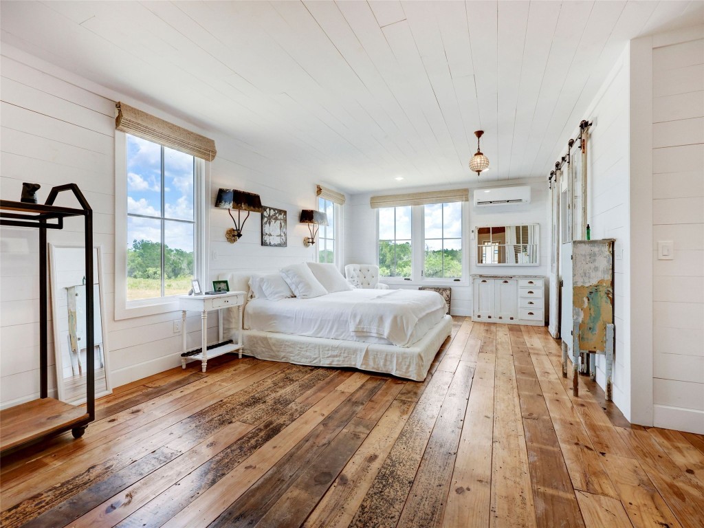 314 Big Sky Ranch Road Smithville, TX 78957 - Photo 32 of 40 a bedroom with a bed and a large window with wooden floor