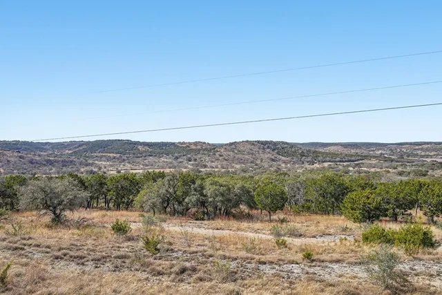 a view of a dry yard with wooden fence