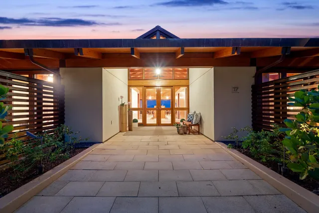 a bathroom with a granite countertop double vanity sink and a toilet