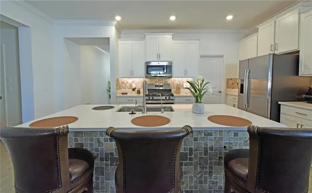 a kitchen with stainless steel appliances granite countertop a sink and a refrigerator