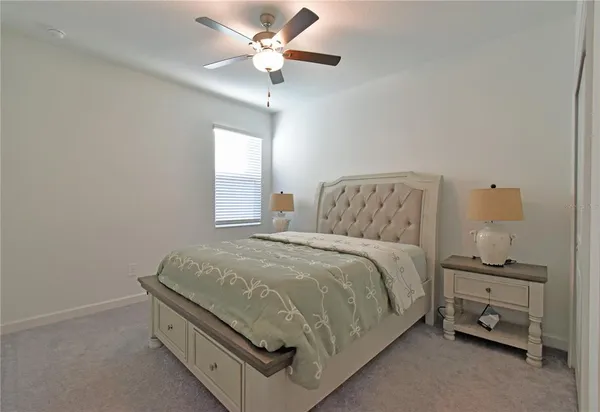 a spacious bedroom with a bed and a chandelier