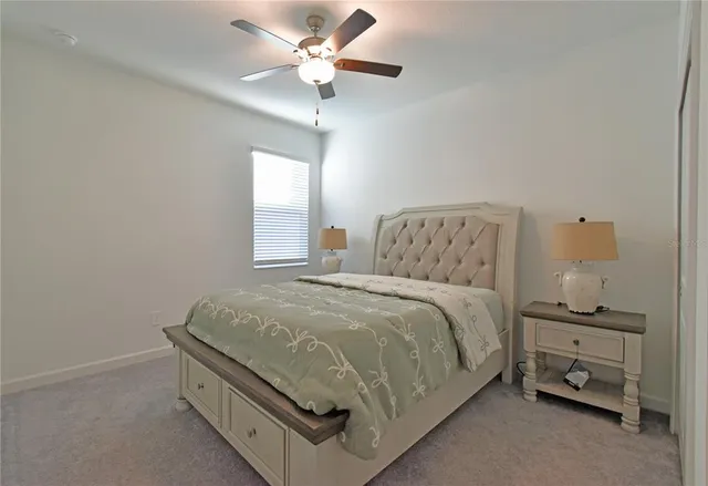 a spacious bedroom with a bed and a chandelier
