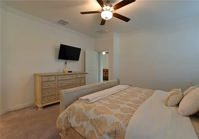a bedroom with a bed and a flat tv screen on dresser