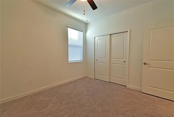 an empty room with chandelier fan