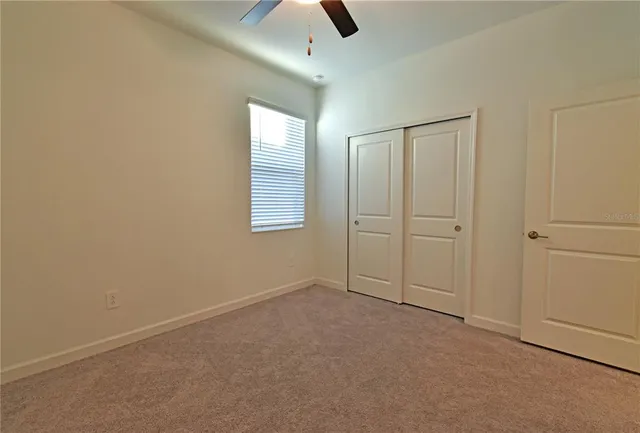 an empty room with chandelier fan