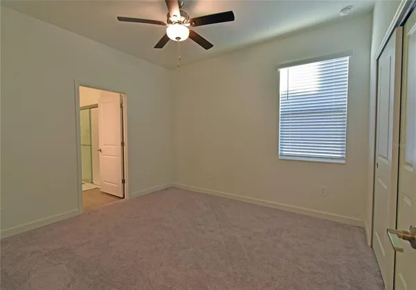 an empty room with windows and fan