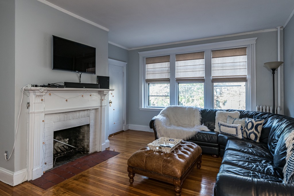 1982 Commonwealth Avenue, Unit 4 Boston, MA 02135 - Photo 4 of 17 a living room with furniture a flat screen tv and a fireplace