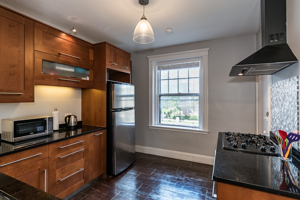 1982 Commonwealth Avenue, Unit 4 Boston, MA 02135 - Photo 7 of 17 a kitchen with stainless steel appliances granite countertop a stove and a refrigerator