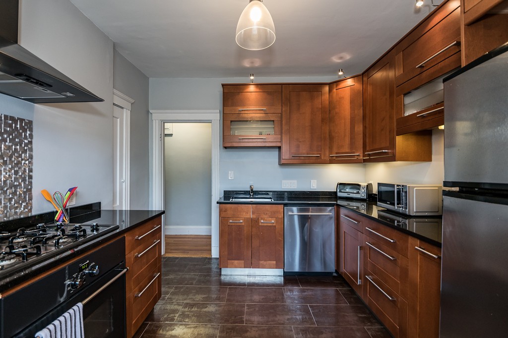 1982 Commonwealth Avenue, Unit 4 Boston, MA 02135 - Photo 8 of 17 a kitchen with stainless steel appliances granite countertop a stove and a sink