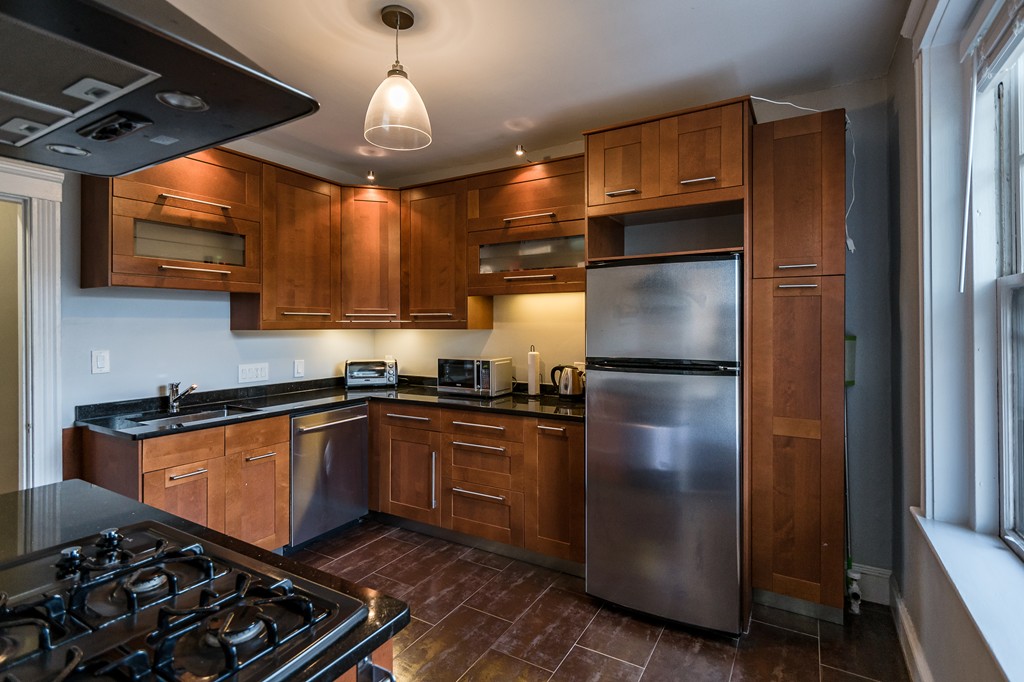 1982 Commonwealth Avenue, Unit 4 Boston, MA 02135 - Photo 9 of 17 a kitchen with stainless steel appliances granite countertop a refrigerator and a sink