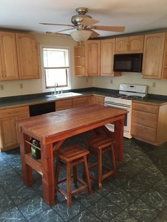 704 Valley Road Barre, MA 01005 - Photo 5 of 19 a kitchen with granite countertop a stove a sink and a microwave