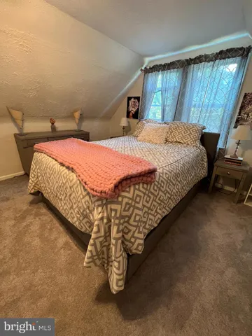 a bed sitting in a bedroom next to a window