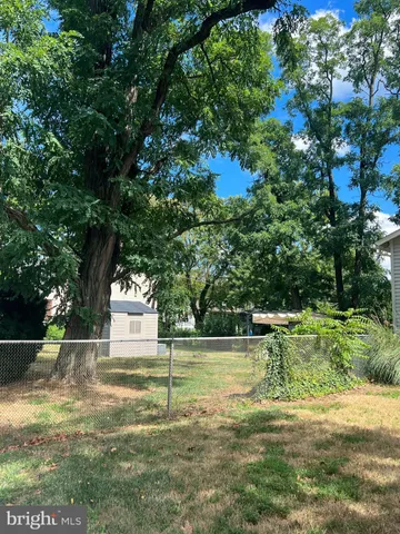 a front view of house with yard and trees in the background
