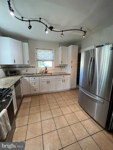 a kitchen with stainless steel appliances granite countertop a refrigerator sink and cabinets