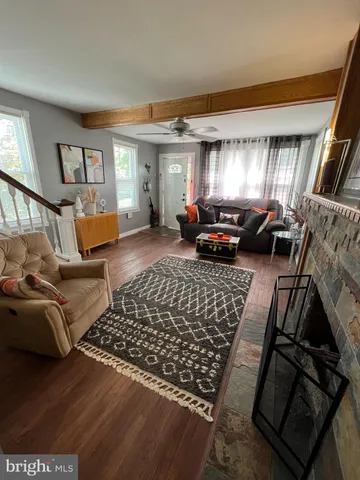 a living room with furniture hard wood floor and a rug
