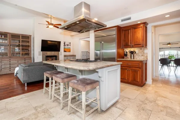 a living room with granite countertop furniture a flat screen tv and kitchen view