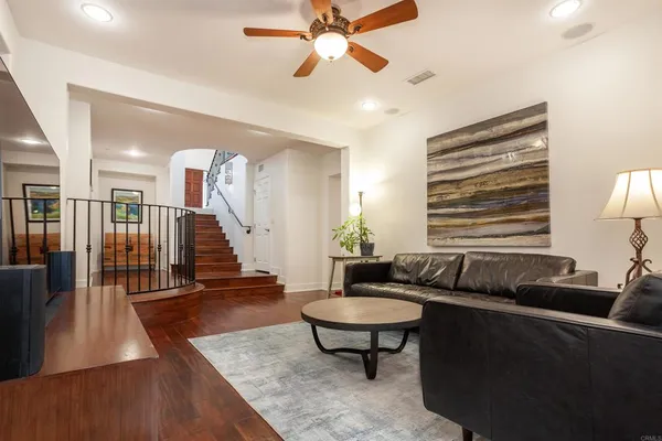 a living room with furniture and a wooden floor