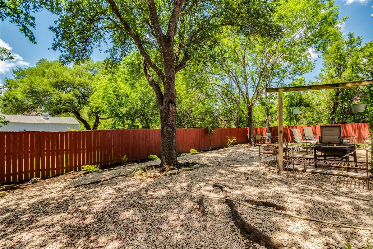 9300 Tea Rose Trail Austin, TX 78748 - Photo 33 of 33 A tranquil yard with mature trees offers a private, rock-covered outdoor living space.