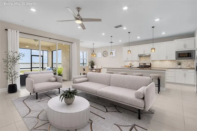 a living room with furniture kitchen view and a large window