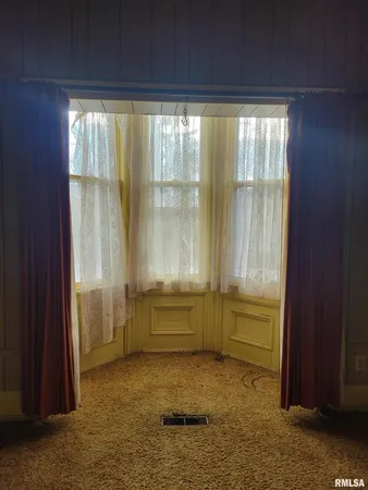 a view of an empty room with a fireplace and a window