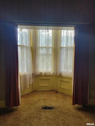 a view of an empty room with a fireplace and a window