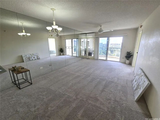 a spacious bedroom with a bed a chandelier and a large window