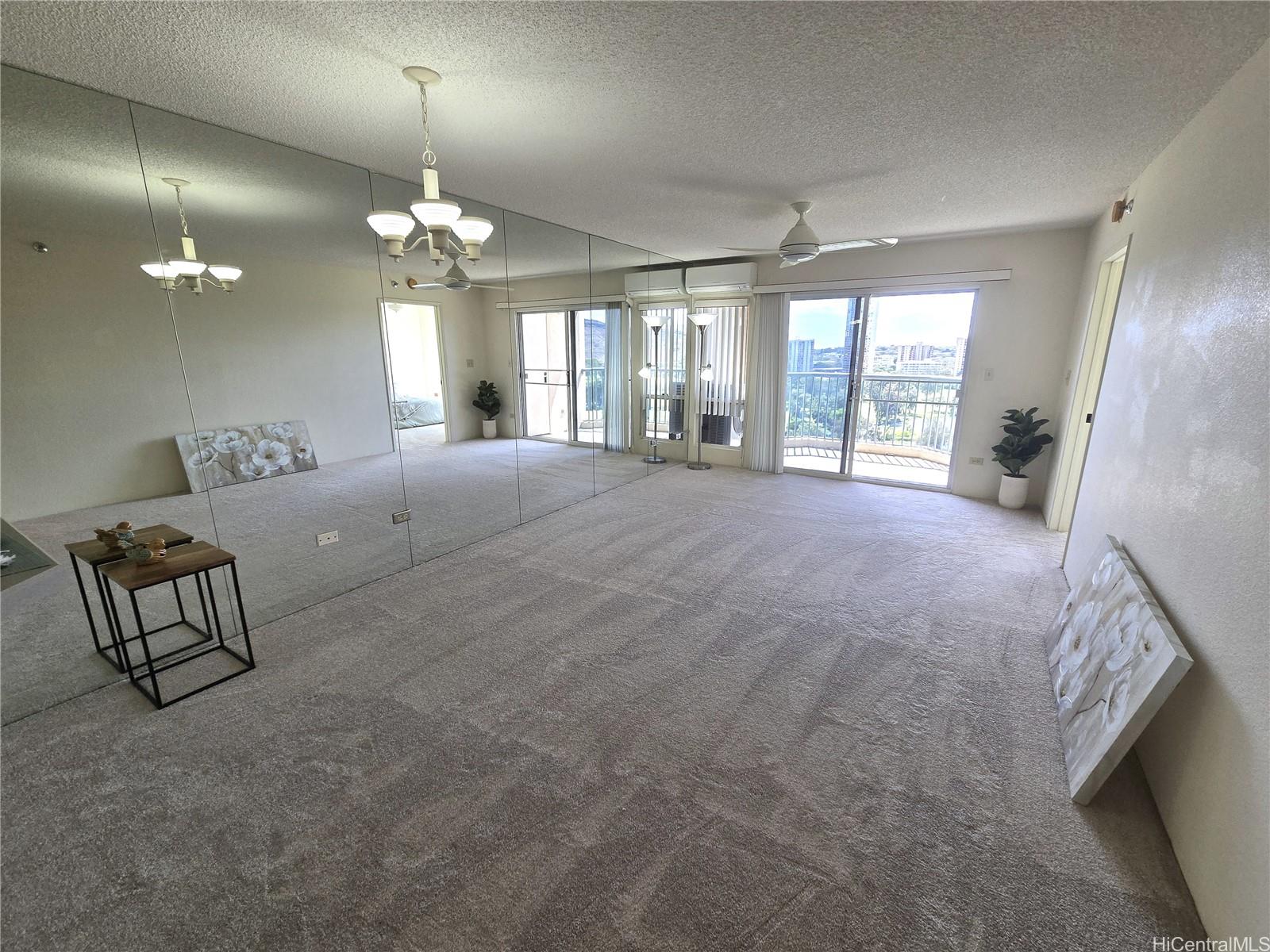 a spacious bedroom with a bed a chandelier and a large window