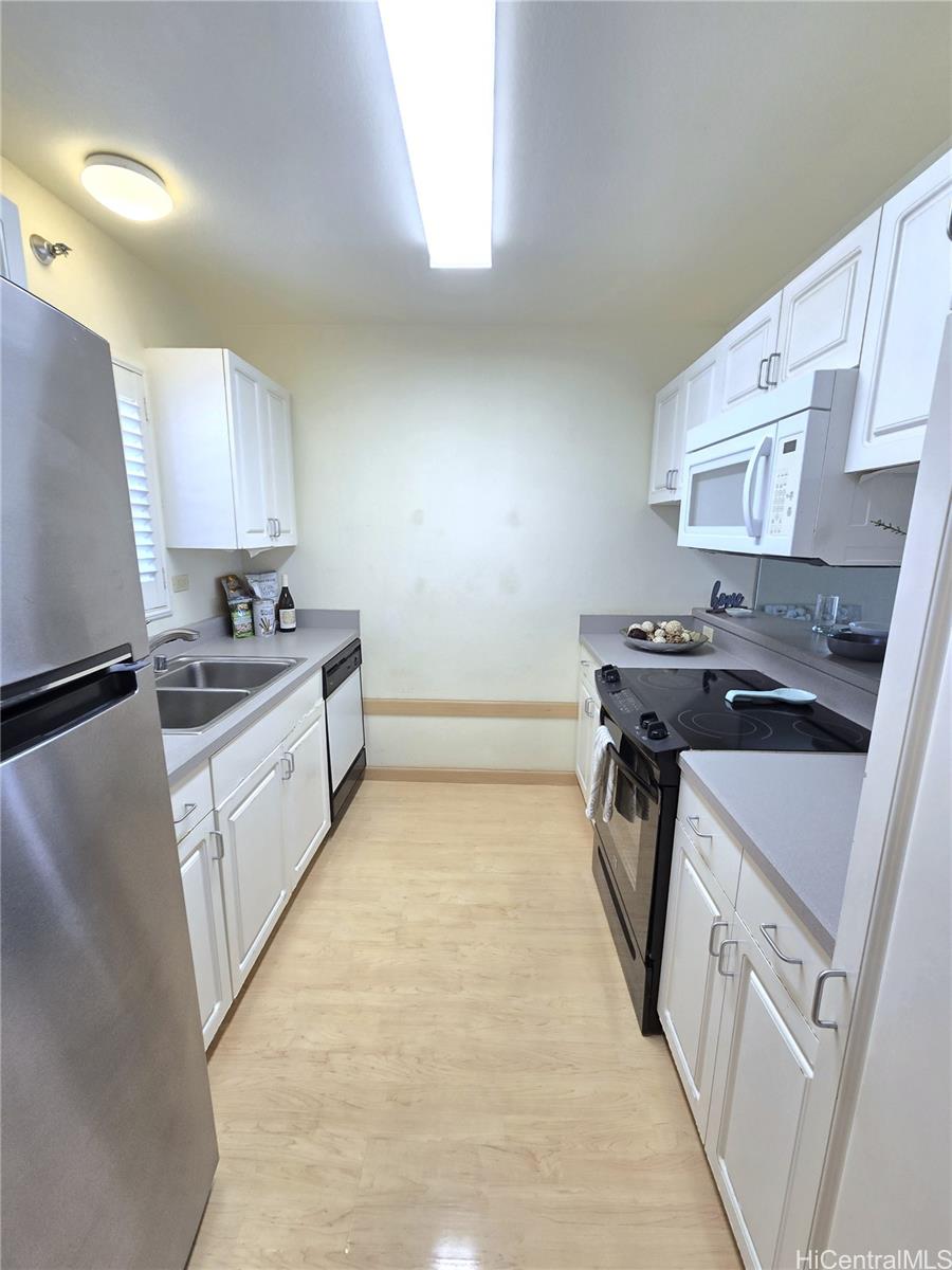 3075 Ala Poha Place, Unit 1504 Honolulu, HI 96818 - Photo 2 of 22 a kitchen with a sink stove top oven and cabinets