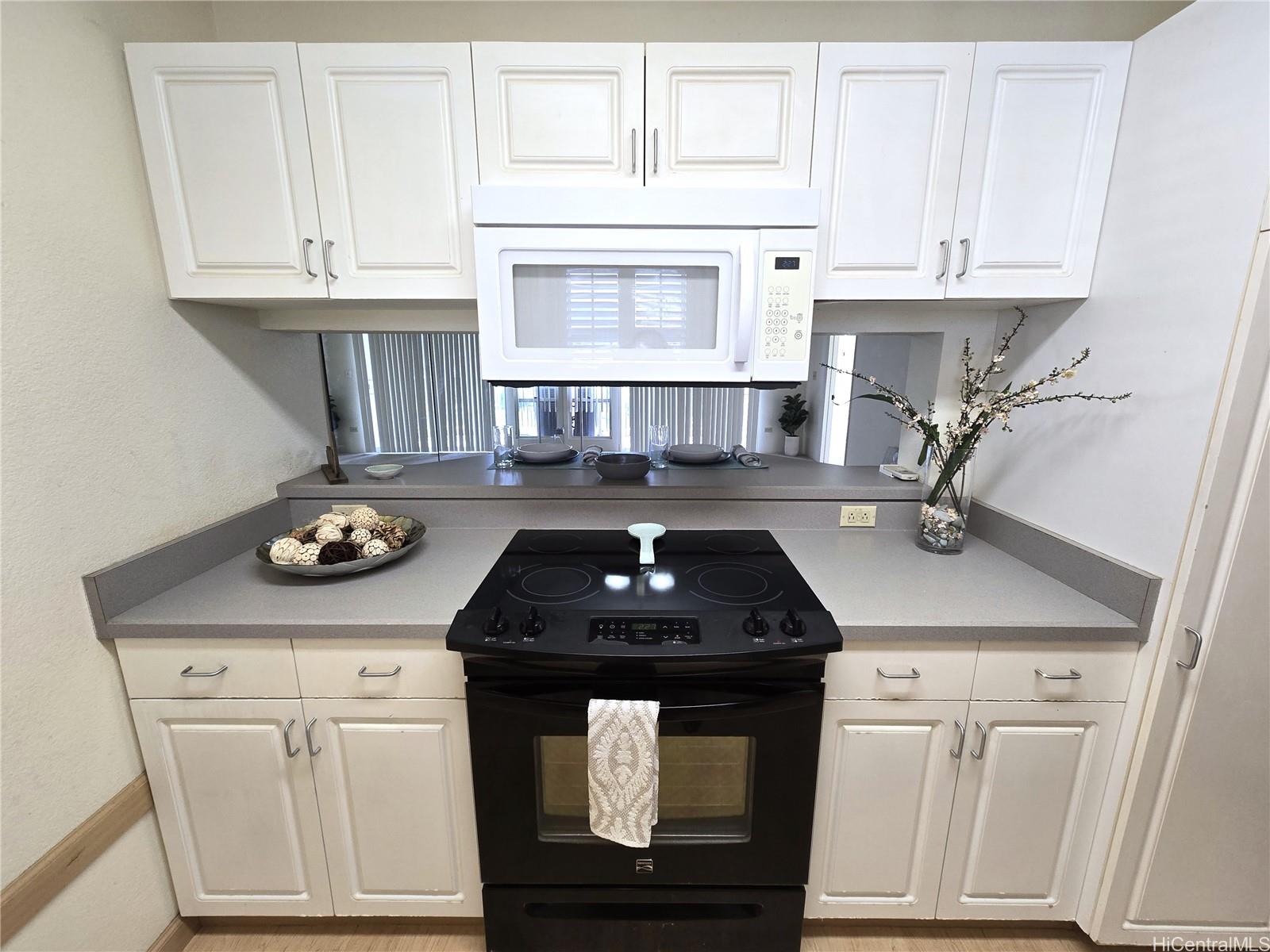 3075 Ala Poha Place, Unit 1504 Honolulu, HI 96818 - Photo 4 of 22 a kitchen with granite countertop a sink stainless steel appliances and cabinets