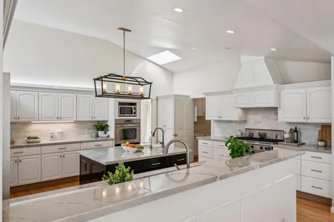 a kitchen with granite countertop a sink a stove and a wooden floors