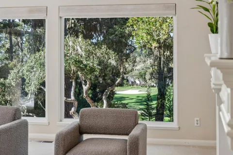 a view of a room with wooden floor and a floor to ceiling window